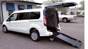 White Transit Connect van with rear entry wheelchair ramp deployed